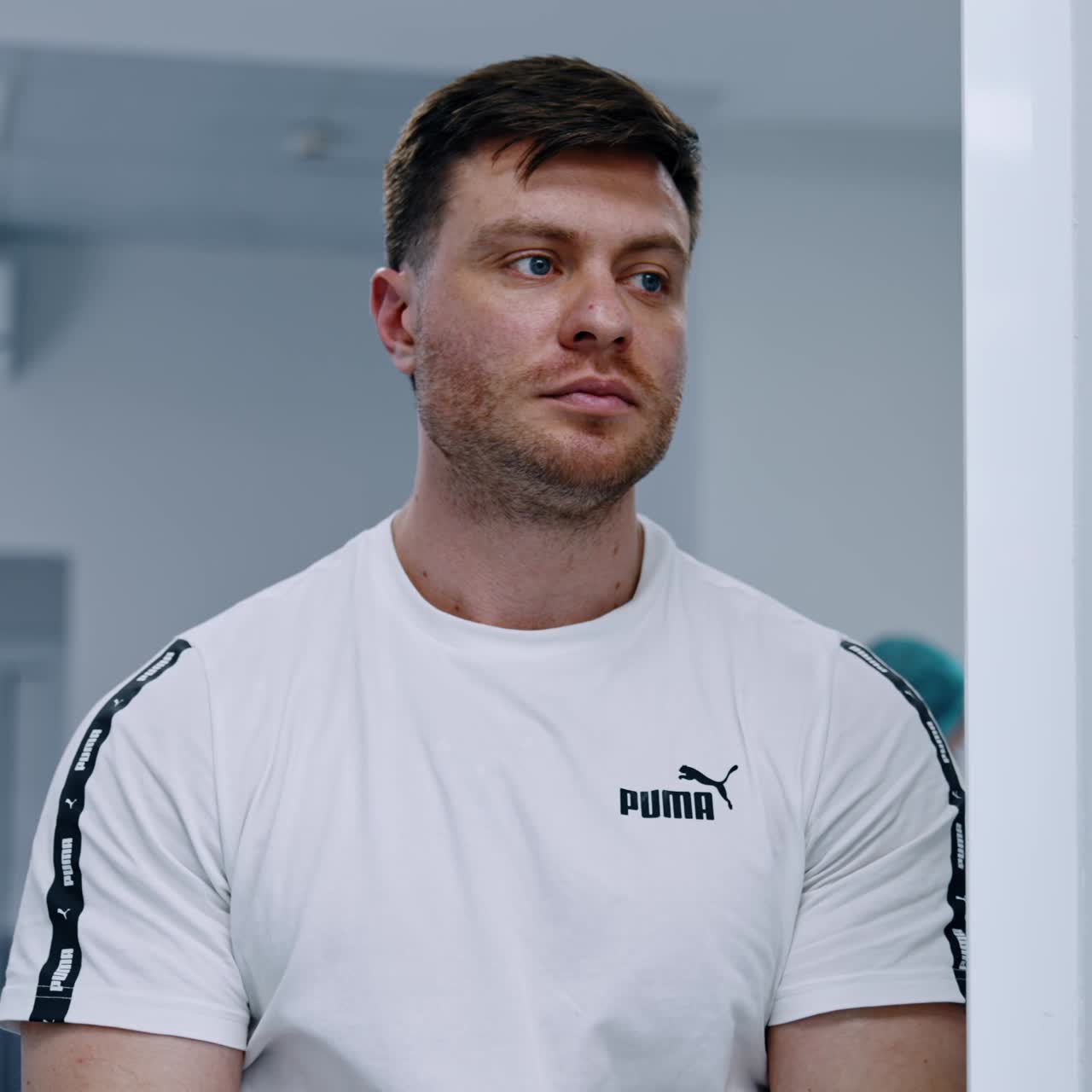 Tired and worried man stands near the surgery room. Man is expecting at the doorway while his wife is prepared for C-section operation