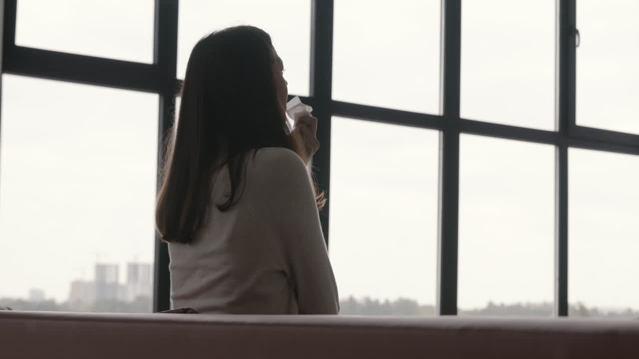 집에서 소파에 앉아 우는 슬픈 여자의 뒷모습