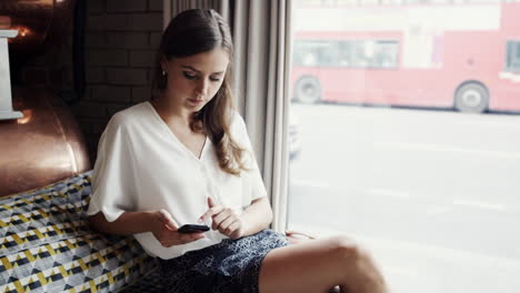 mujer de negocios atractiva piernas sexy usando teléfono móvil inteligente café viajeros de la ciudad en el fondo