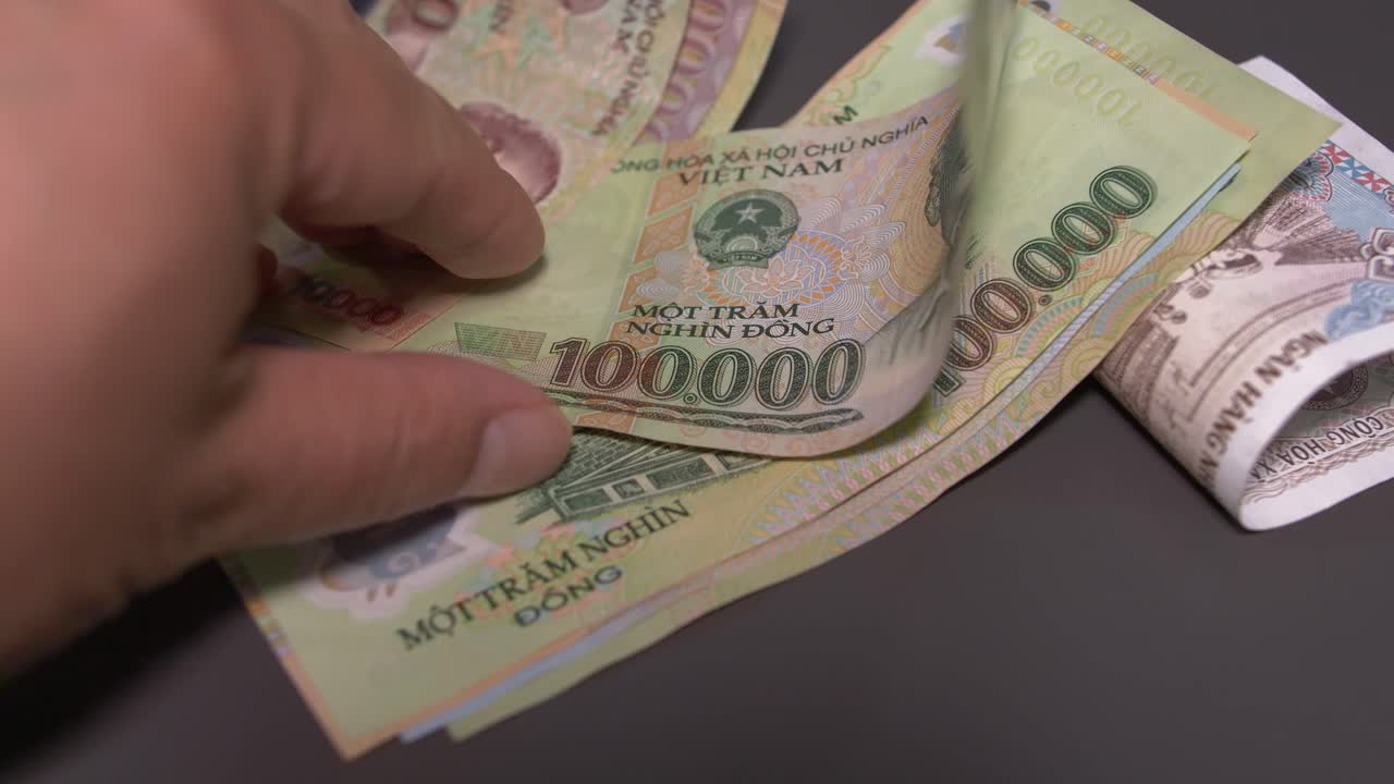 person looks at large vietnamese currency denominations