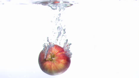 manzana cayendo en el agua en súper cámara lenta