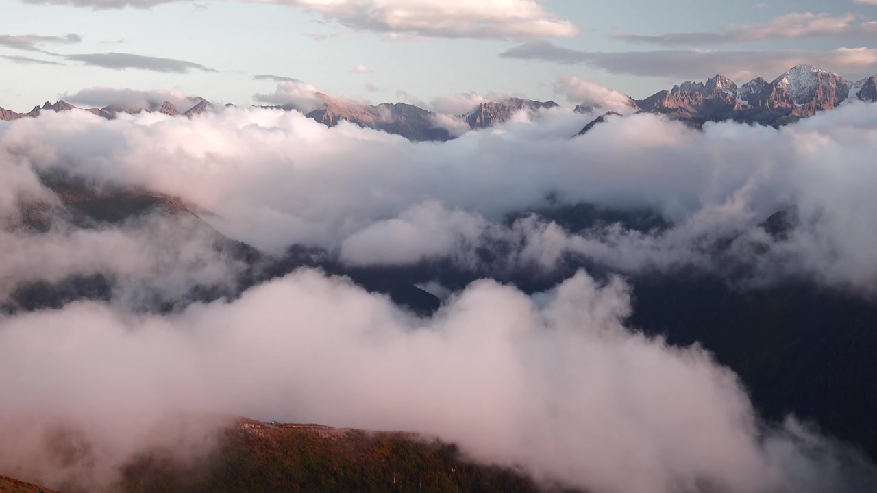 Aerial View of Majestic Mountain Peaks Above Thick Clouds