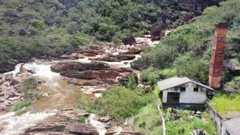 An-old-abandoned-building-beside-a-rocky-river-in-barren-hills