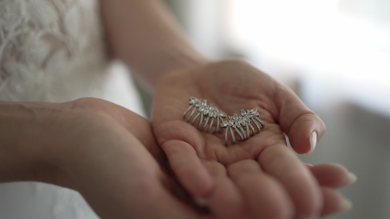 Bride with wedding earrings in hand