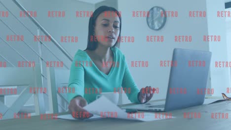 Animation-of-multiple-retro-text-banners-over-african-american-woman-holding-a-document-using-laptop