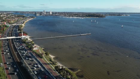 vista aérea del tráfico en la autopista con el río swan durante la puesta de sol en la ciudad de perth