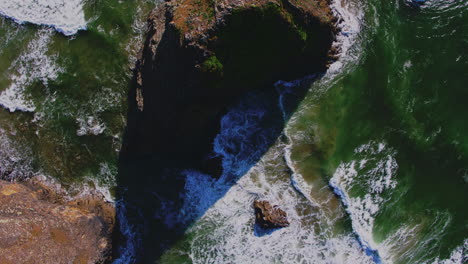 aerial rising directly above ocean rock, wave patterns and textures