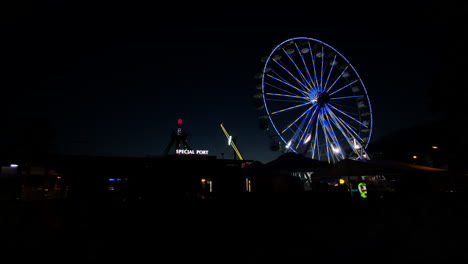 colorful ferris wheel against the night sky at the amusement park in poland - wide shot