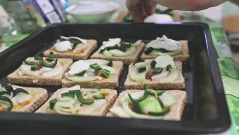 Hacer-Tostadas-En-Una-Bandeja-Para-Hornear-Con-Chile-Jalapeño-Picante-Verde,-Cebolla-Blanca-Y-Queso-Mozzarella