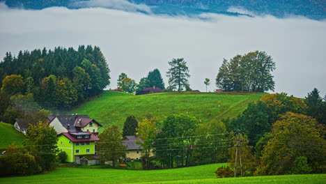 Acogedor-Pueblo-Alpino-Con-Niebla-Fluyendo-Por-Encima-De-Las-Nubes,-Vista-De-Lapso-De-Tiempo