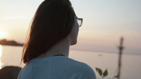 niña mira el agua durante el atardecer