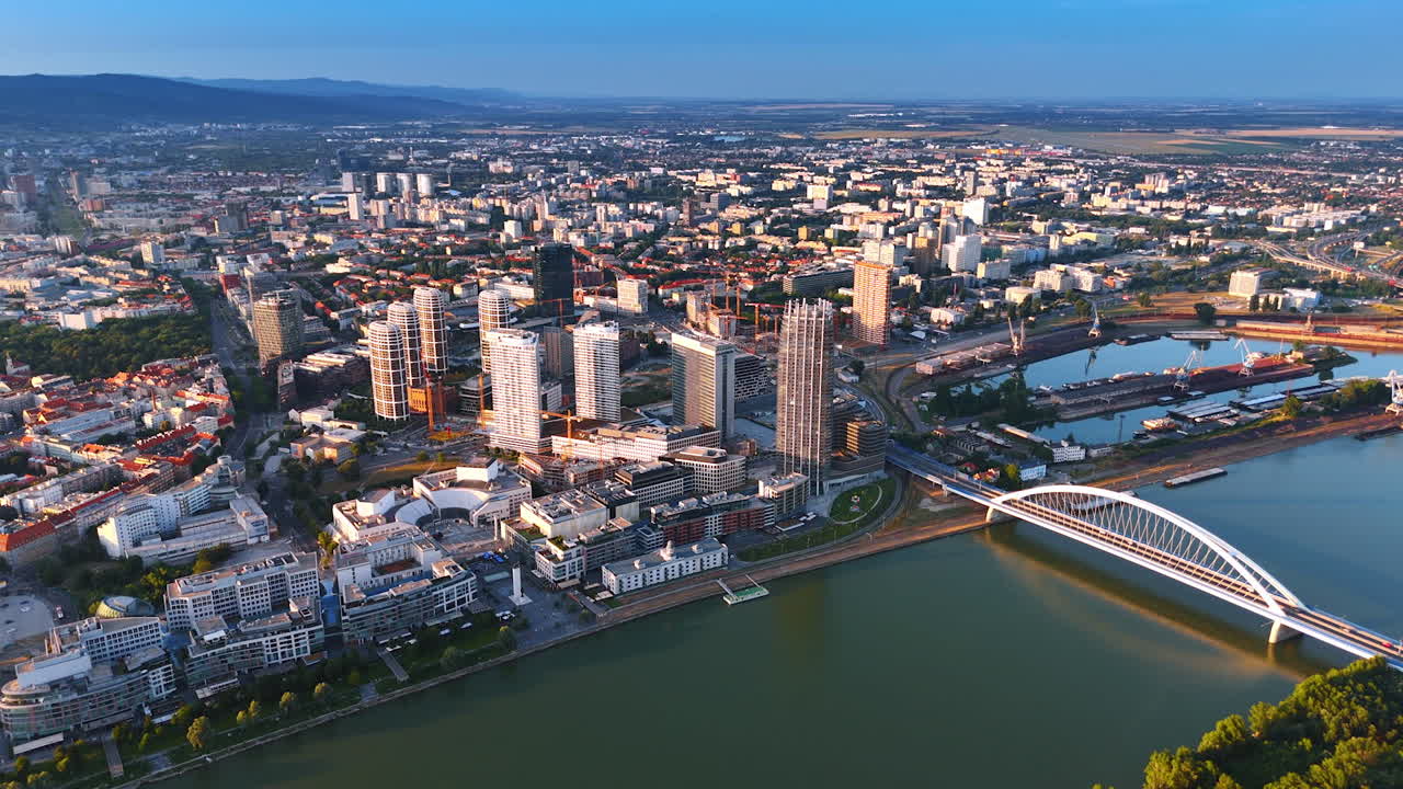 Modern cityscape of sunlit Bratislava, Slovakia. Footage above the Danube with the Appolo Bridge