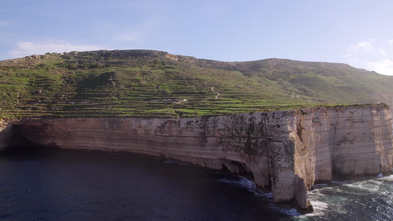 imágenes de drones de acantilados muy altos junto al mar, con exuberante vegetación en lo alto de los acantilados en malta