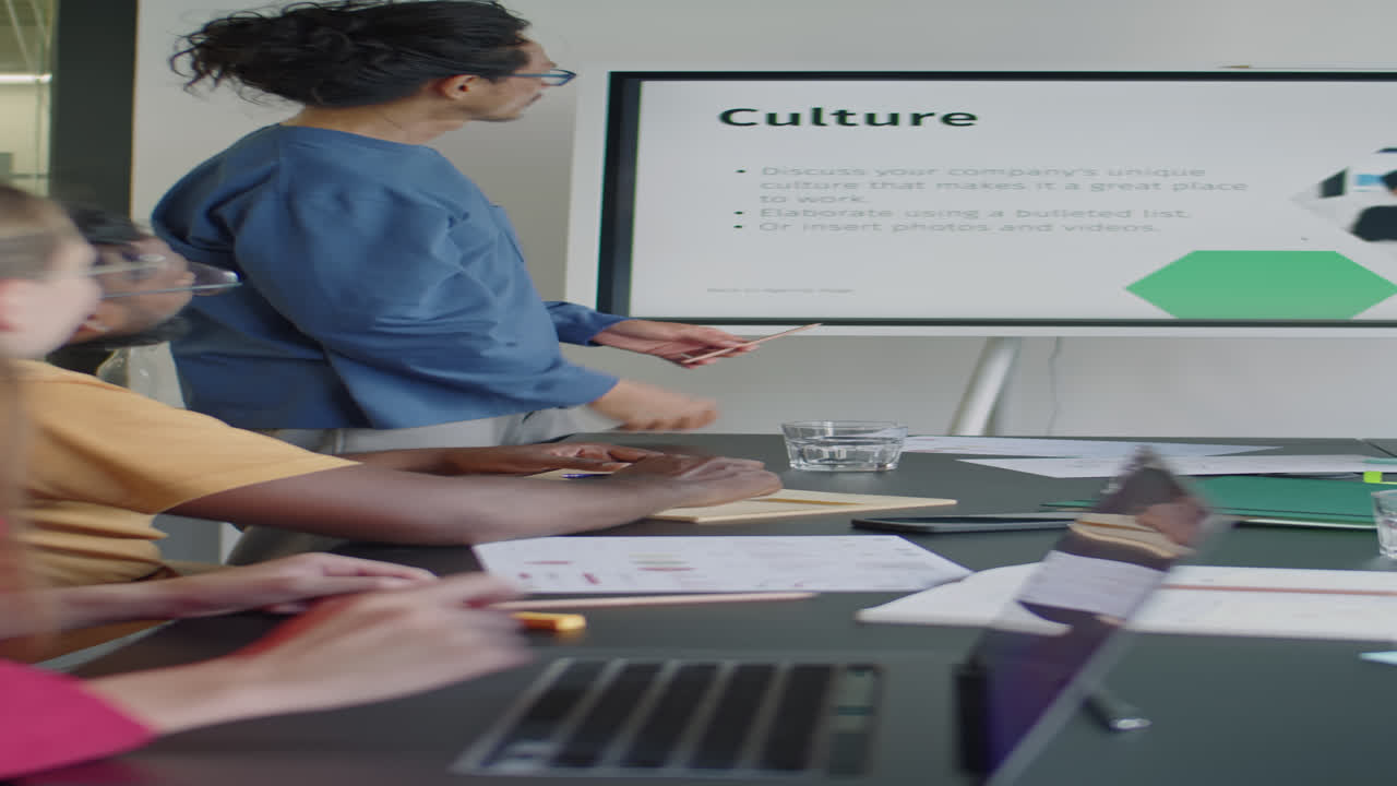 Asian Man Presenting Project at Business Meeting