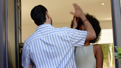 friends greeting each other with high five, enjoying time together indoors