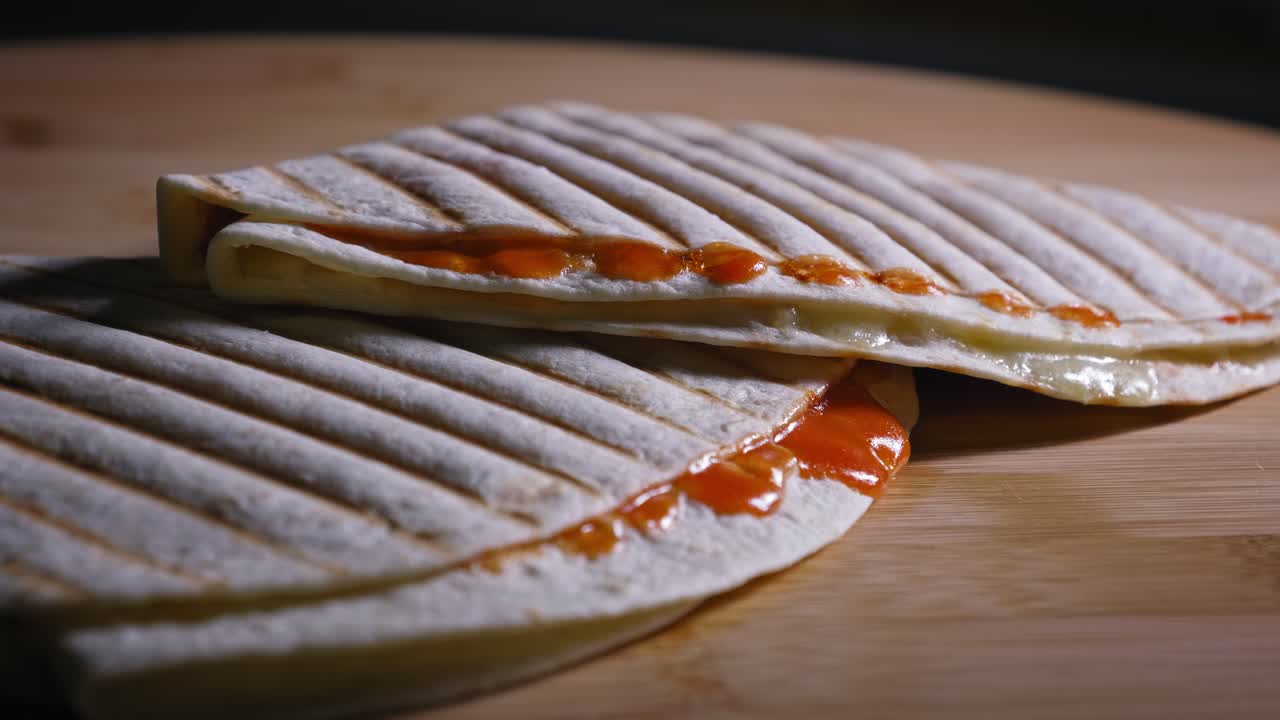 tortillas de dos cuartos con salsa de naranja colocadas una encima de la otra sobre una mesa de madera