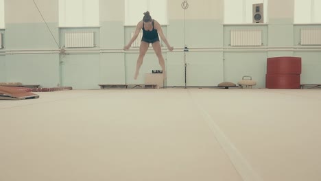 female fitness athlete in the gym performs an acrobatic set