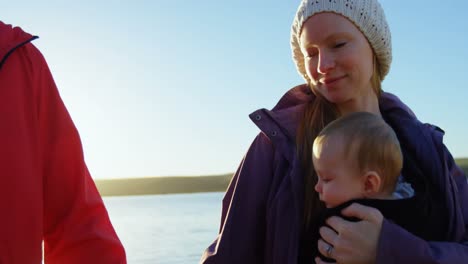 Parents-walking-together-holding-their-baby-4k