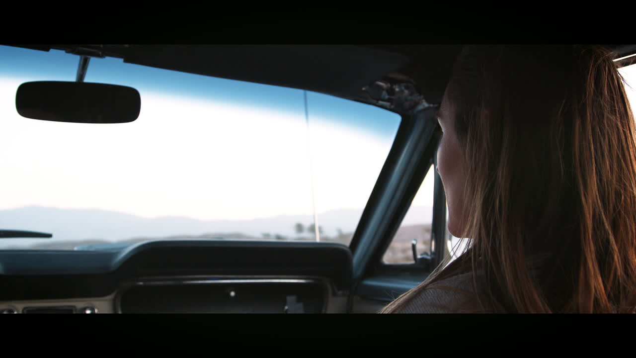 Young woman in front passenger seat of car on the highway