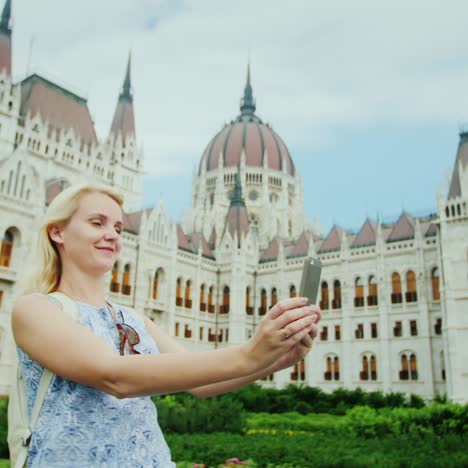 travel around europe - a tourist does selfie on the background of the hungarian parliament in budapest 1