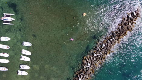 bird eye aerial view for speed boats and yachts at the sea and small rocky shore with sun light reflections