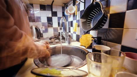 timelapse of modern woman tidying dishes in cozy kitchen with evening ambiance