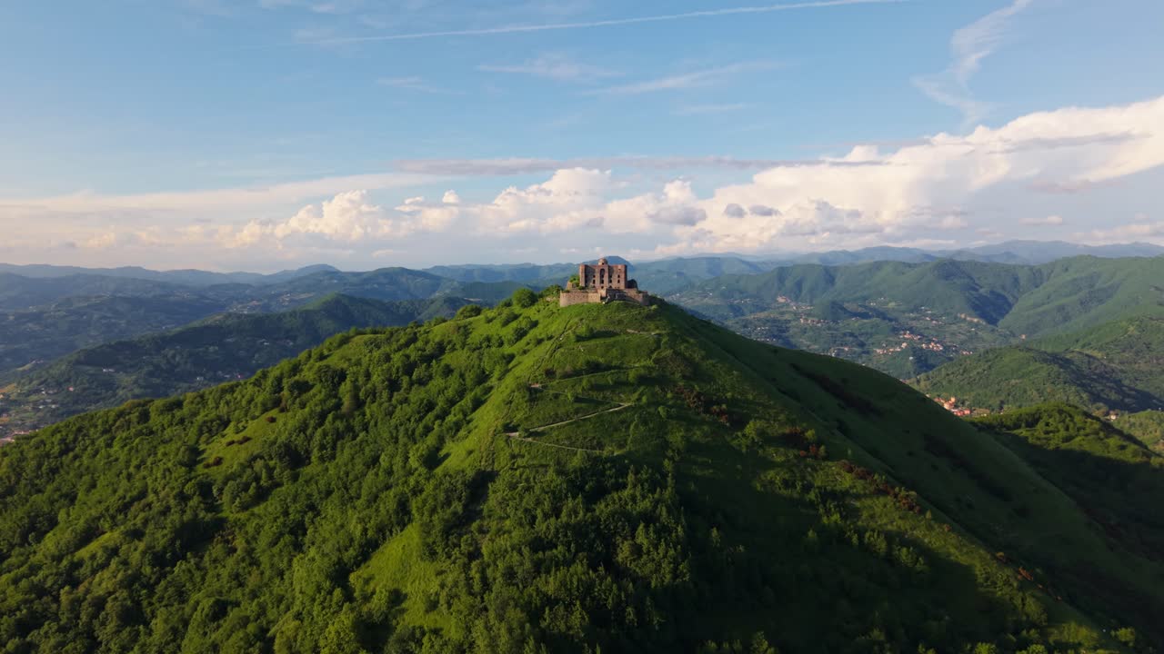 Ancient fort in Italy surrounded by lush greenery, mountains and open skies