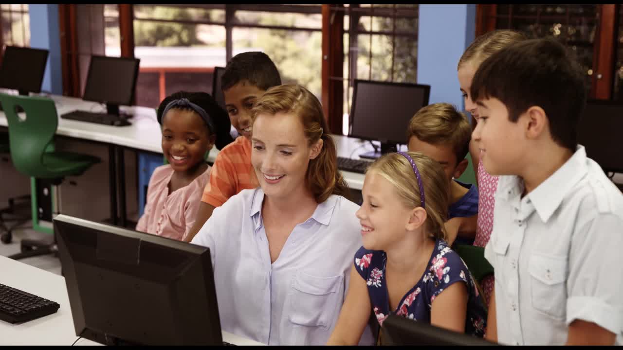 Teacher assisting school kids on personal computer in classroom