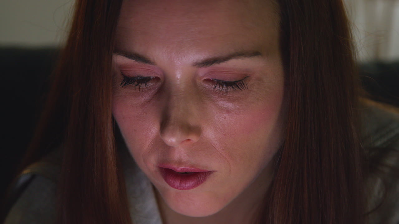 밤에 집에서 소파에 누워있는 여성의 클로즈업 스트리밍 또는 모바일 폰에서 온라인 콘텐츠를 보는 것