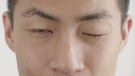 close up asian man face smiling looking happy winking perfect skin