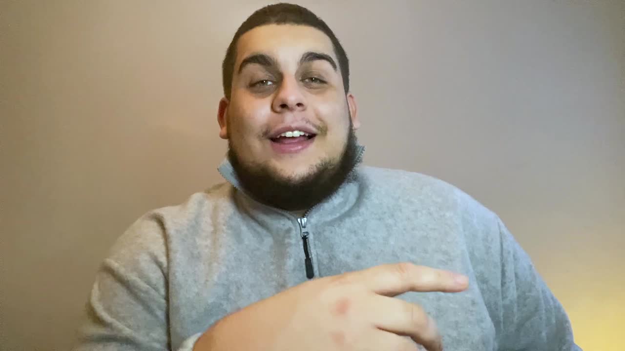 joven estudiante universitario contando una historia divertida directamente a la cámara durante una videollamada