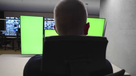 system security specialist working at system control center. room is full of green screens, chroma screen and security