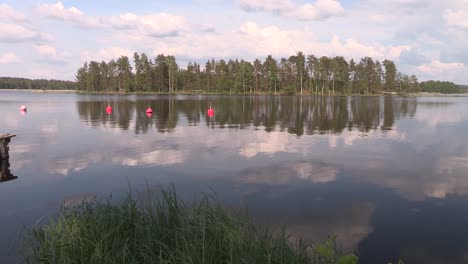 Toma-Panorámica-Del-Lago-Con-Bosques-De-Coníferas-Y-Nubes-En-Finlandia