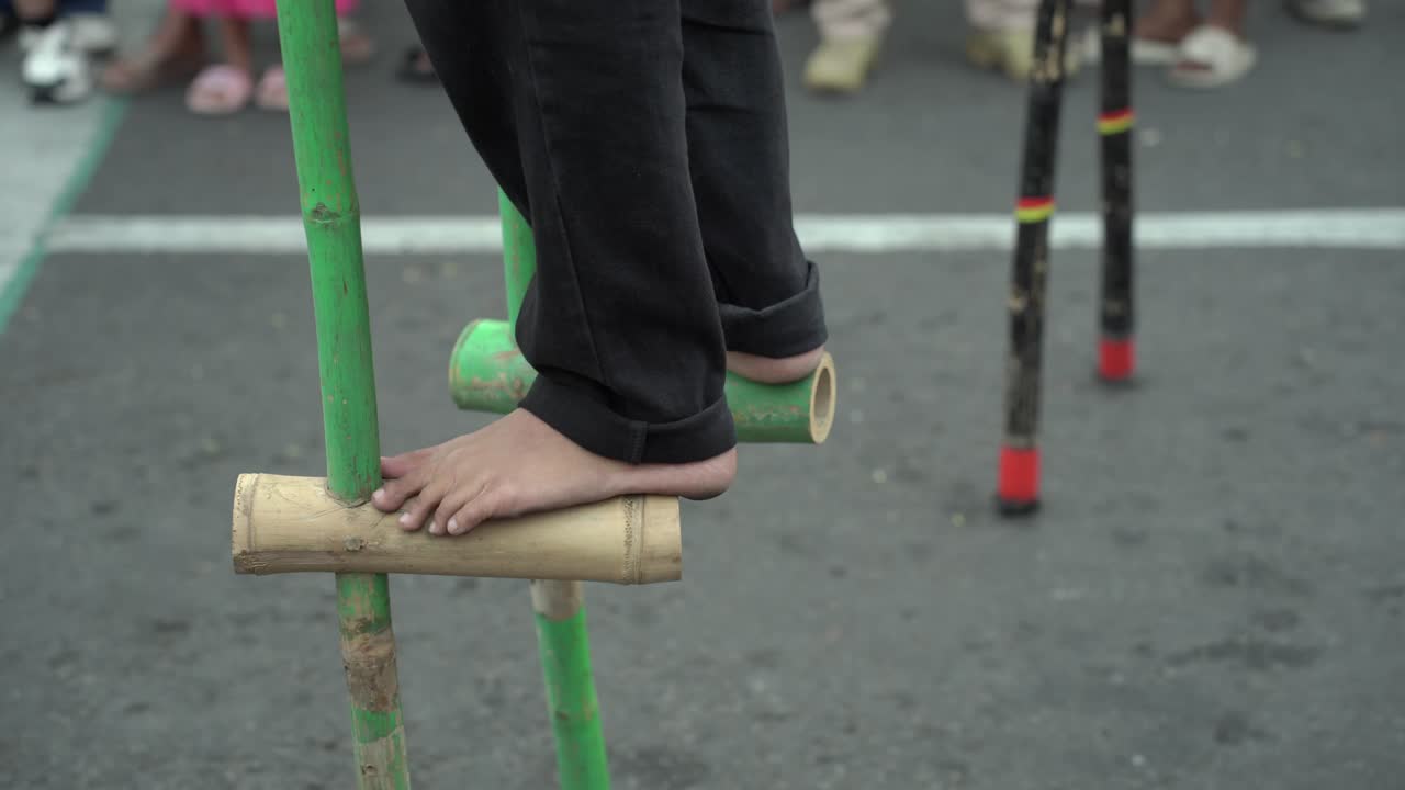 Closeup of feet playing bamboo stilts at a festival in Yogyakarta. Bamboo stilts are a traditional Indonesian game