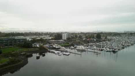 a stunning drone view of mariner square in alameda, featuring docked yachts, piers, and the tranquil beauty of the waterfront.