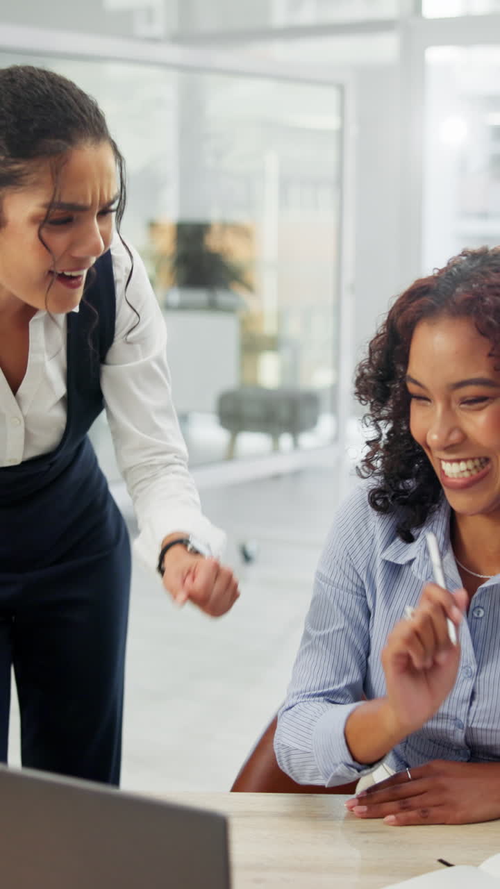 Duas empresárias felizes rindo e celebrando em um escritório moderno