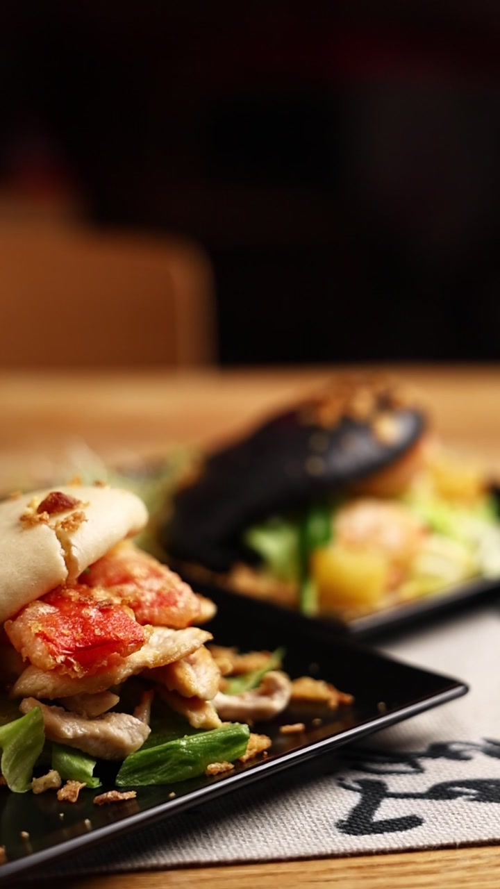 Gourmet Bao Buns Served on Black Plates in Restaurant