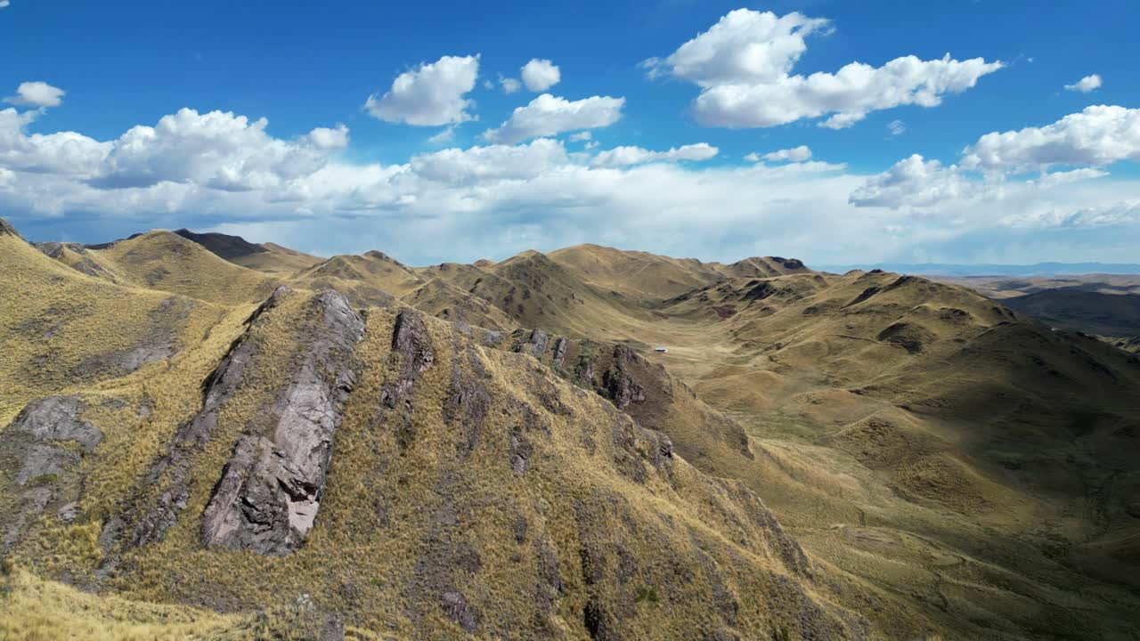 Aerial 4K drone footage soaring over the Peruvian Andes, where green valleys and golden ridges glow under dramatic evening light