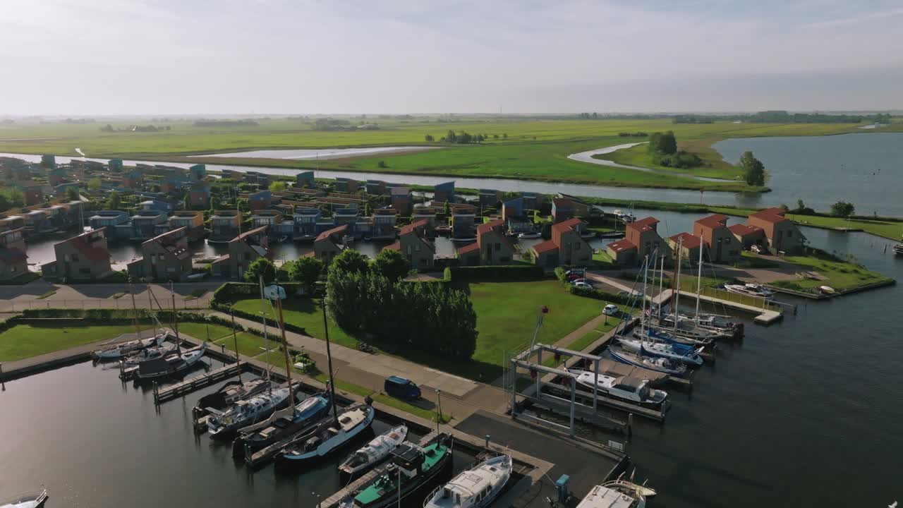 Drone zooms out to reveal complete marina layout, nearby boats, docks, and waterways in clear daylight