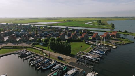 Drone zooms out to reveal complete marina layout, nearby boats, docks, and waterways in clear daylight