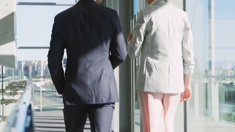dos jóvenes empresarios caminando en una oficina moderna