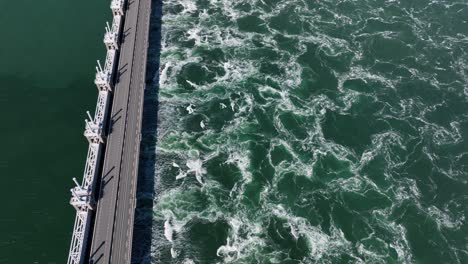 aerial tilt down shot of storm surge barrier oosterschelde in zeeland during sunny day