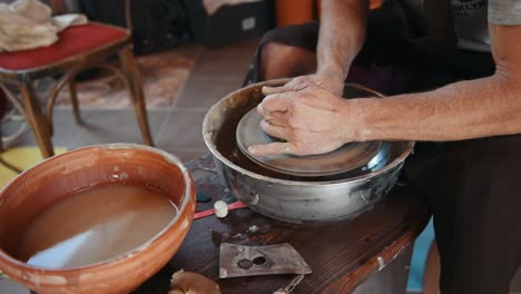 ceramist uses potter's wheel and creates a handmade clay product