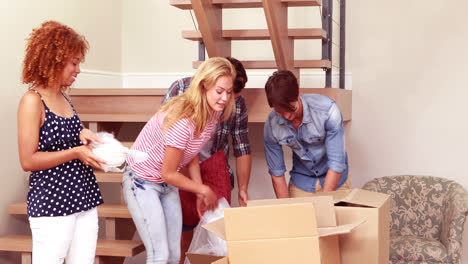 smiling friends moving boxes together while saying goodbye