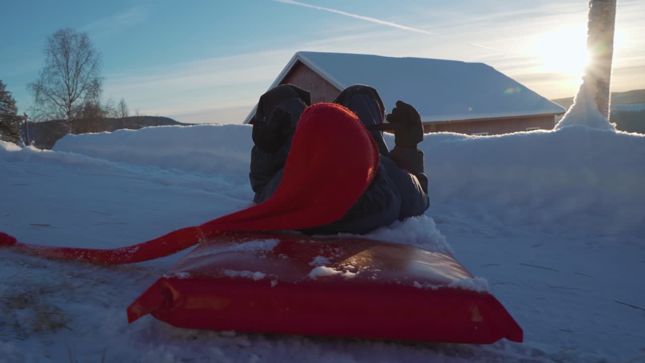 tiro pov de niño feliz en trineo cuesta abajo montañas nevadas en noruega durante la puesta de sol - girando con trineo