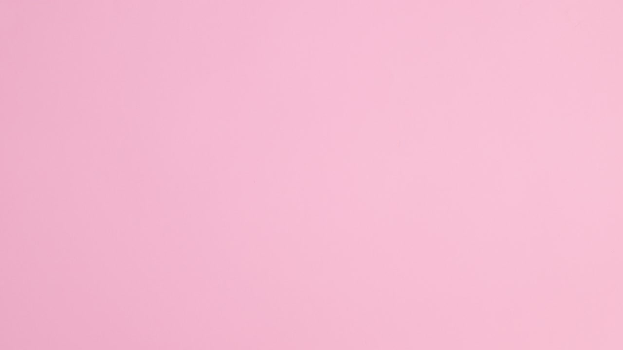 Summer trendy beach accessories and copy space frame appear on pastel pink background. Stop motion flat lay