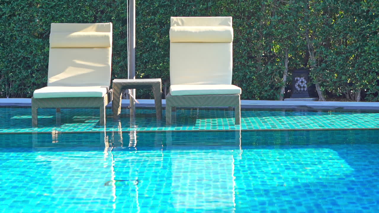 White deckchairs in shallow swimming pool water