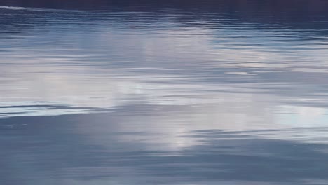 distorted reflection of the clouds on the rippled surface of the water