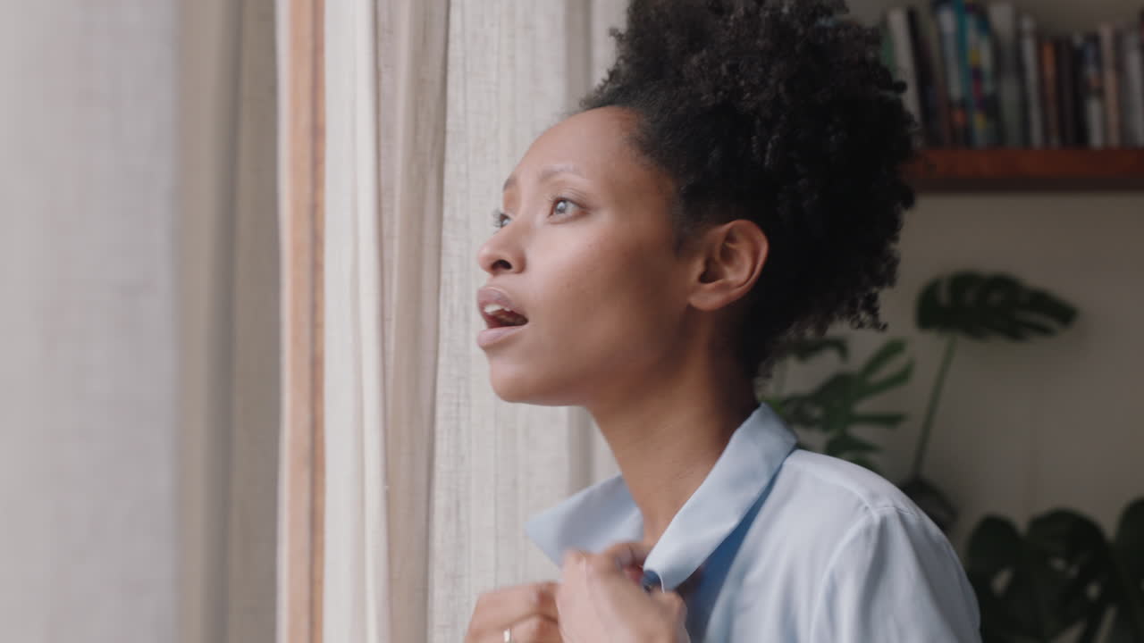 beautiful african american woman dressing getting ready late for work looking out window enjoying fresh new day feeling rested