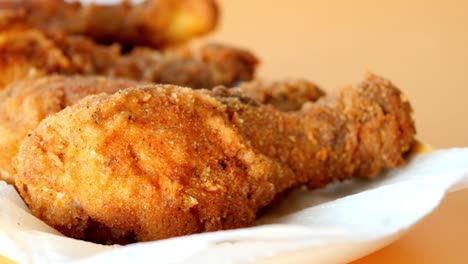 close up of crispy fried chicken drumsticks on a white plate